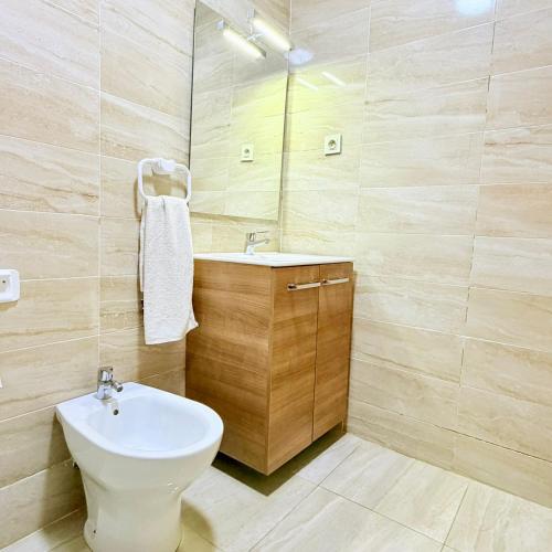 a bathroom with a white toilet and a sink at 2BR Apt with Pool View in City Center in Oulad Akkou