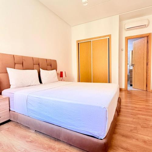 a bedroom with a large white bed in a room at 2BR Apt with Pool View in City Center in Oulad Akkou