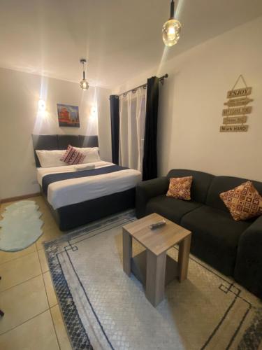 a living room with a bed and a couch at West suites kisauni road in Nairobi