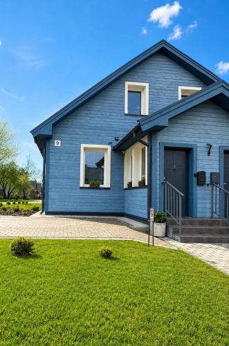 a blue house with a lawn in front of it at Slėnis in Plungė