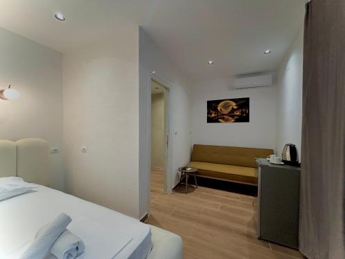a bedroom with a bed and a couch in it at Olive garden private Suite in Ksamil