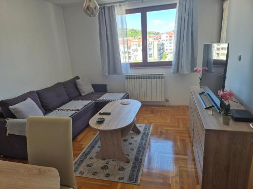 a living room with a couch and a table at Apartman Dobrinja in Sarajevo