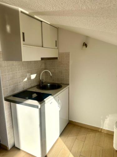 a small kitchen with a sink and a counter at Sara Apartments in Makarska