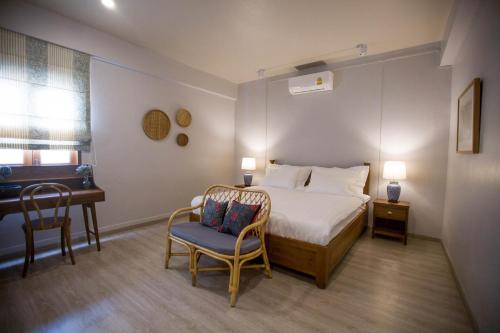 a bedroom with a bed and a desk and a chair at Vera Nidhra - Self check-in after 6pm in Bangkok