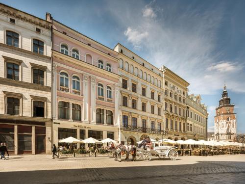 a horse drawn carriage in front of a large building at The House 14 in Krakow