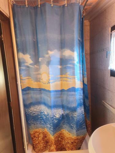 a shower with a blue shower curtain in a bathroom at Chata Vrcov in Vrcov