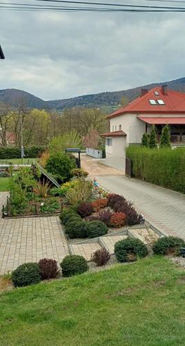 a garden with a brick walkway in front of a house at Pod Górą in Wiśniowa