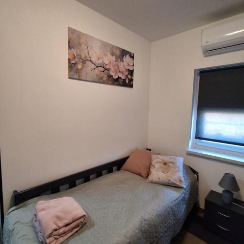 a bedroom with a bed and a painting on the wall at Studio apartmani Atlantik in Nedelišće