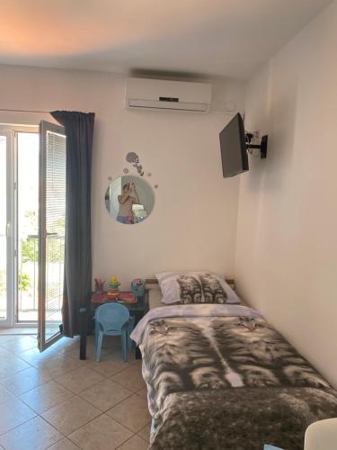 a bedroom with a bed and a table with a mirror at Botic Apartments in Šilo