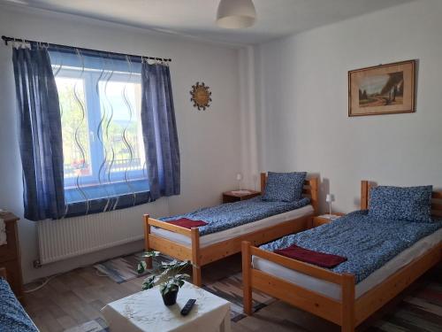 a bedroom with two beds and a window at Gabriella Vendégház in Vadna