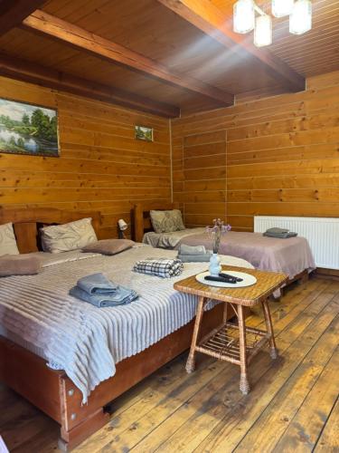 a bedroom with two beds and a table in it at Готель Близнюки in Vorokhta