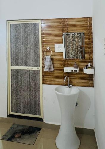 a bathroom with a toilet and a sink and a window at Si' Casa in Mandrem