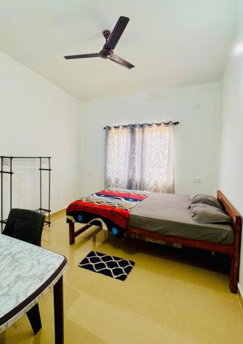a bedroom with a bed and a ceiling fan at Si' Casa in Mandrem