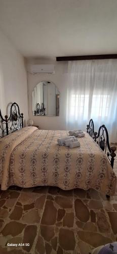 a large bed in a bedroom with a large mirror at B&B Sa Rocca Manna in Laerru