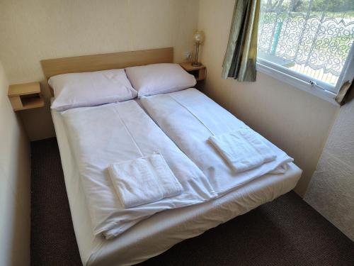 a bed with white sheets and pillows in a room at Chata Darwin in Terchová