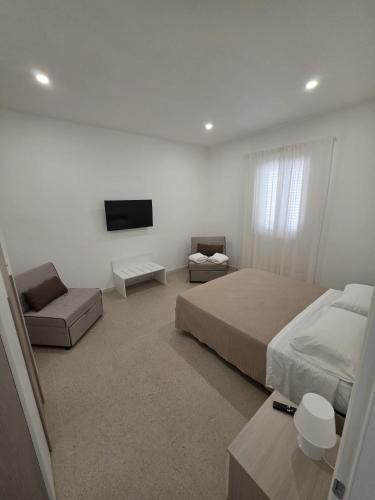 a bedroom with a bed and a tv and a couch at Piccola Chappy in Taranto