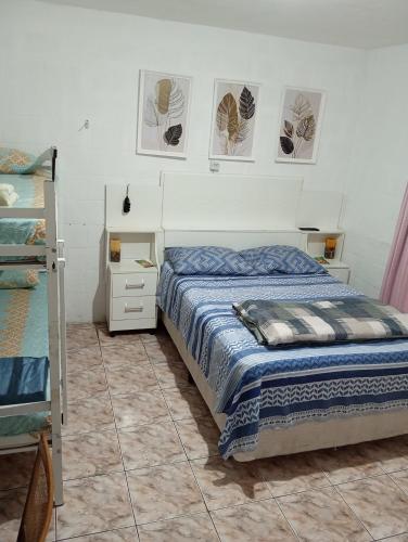 a bedroom with a bed and some pictures on the wall at Maria Hostel Brasil gru in Guarulhos