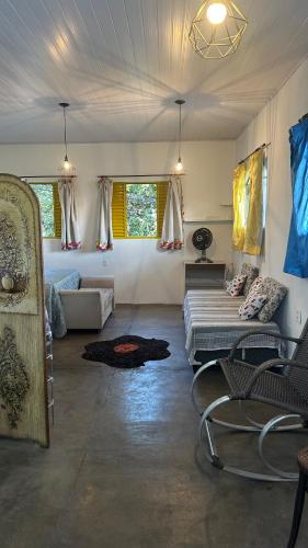 a living room with a couch and chairs in a room at HOSTEL Divinópolis in Divinópolis