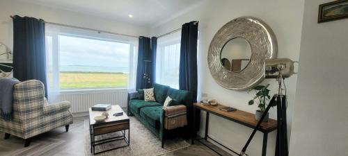 a living room with a couch and a mirror at Atlantic Way Suites Doonbeg Co Clare in Doonbeg