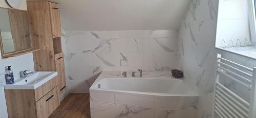 a white bathroom with a tub and a sink at Krčma na statku in Zásmuky