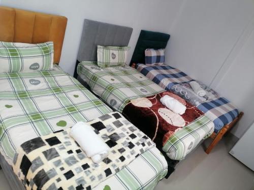 three twin beds sitting in a room with at 36 the trout lodge in Goodwood