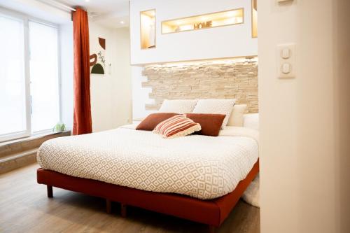 a bed in a room with a brick wall at L'Escapade Etoilée Rosheim in Rosheim