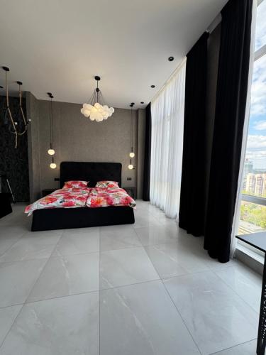 a bedroom with a bed and large windows at Delmar Apartment Center in Dnipro
