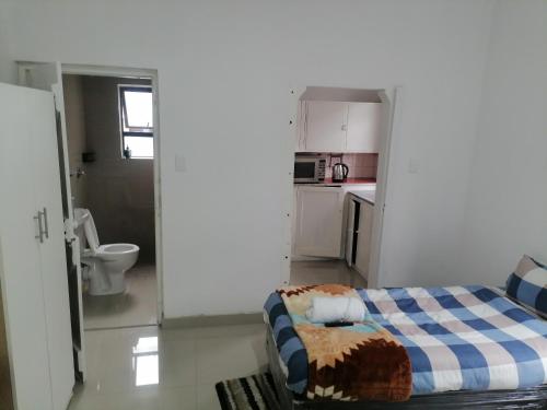 a small room with a bed and a kitchen at 36 the trout lodge in Goodwood