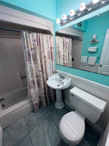 a bathroom with a sink and a toilet and a mirror at Apollo Motel in Wildwood Crest
