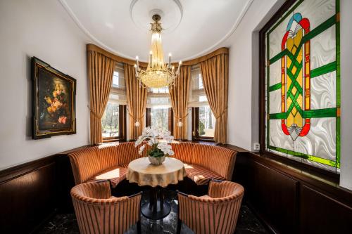 a dining room with a table and chairs and a chandelier at Hotel Most Slávy in Martinske Hole