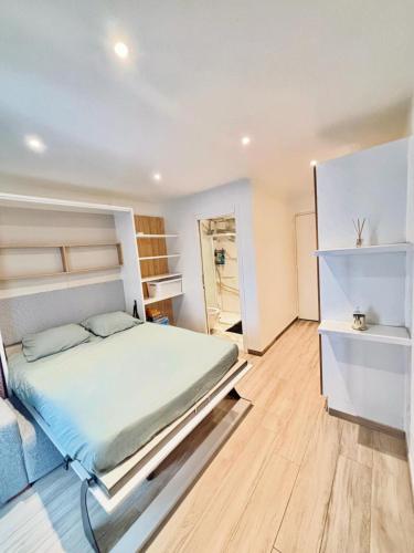 a bedroom with a large bed and wooden floors at Cozy studio Annecy in Poisy