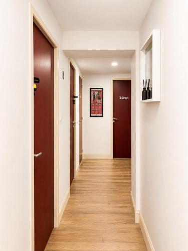a hallway with two doors and wooden floors at Chambre moderne au Petit Bayonne chez particulier in Bayonne