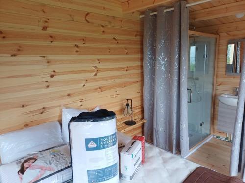 a room with a wooden wall with a bed and a bathroom at Douglas in Saint-Racho