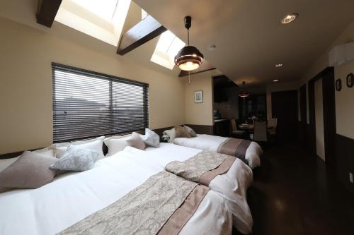 two large beds in a room with a window at KEI VILLA Tsujido in Takata