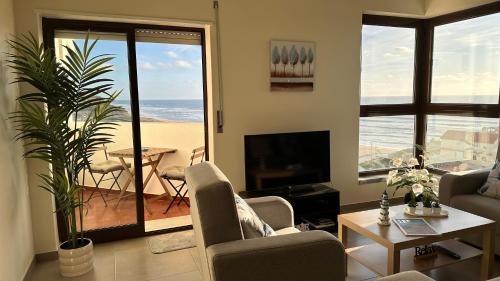 a living room with a view of the beach at Face a l'océan, vue panoramique, 3 min a pied de la plage, Praia da areia branca in Praia da Areia Branca