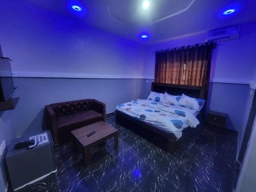 a bedroom with a bed and a chair and a table at Kings Garden Inn in Ekrokpe
