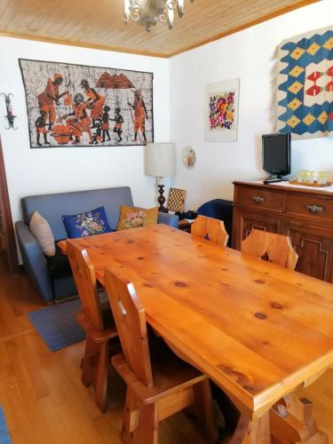 a dining room with a wooden table and a couch at Casa Camomilla in Creto
