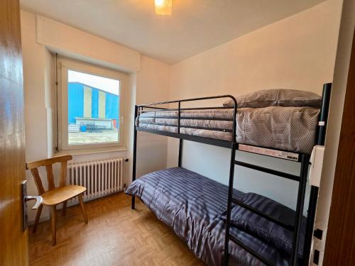 a bedroom with two bunk beds and a chair and a window at Maison BAVANS in Bavans