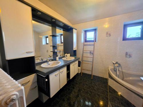 a bathroom with two sinks and a large mirror at Maison BAVANS in Bavans