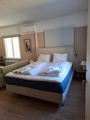 a bedroom with a large bed with white sheets and pillows at Tulip Adventure in Deje
