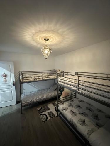 a bedroom with two bunk beds and a chandelier at Paris Giverny familles & professionnels in Freneuse