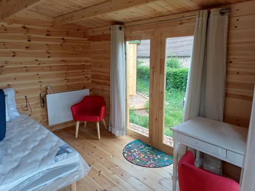a bedroom with a bed and a desk and a window at Grand Chêne in Saint-Racho