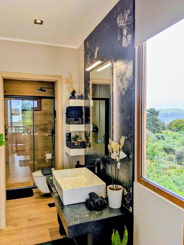a bathroom with a sink and a large window at Stone Villa Halepa Pool, Sea View Peaceful Luxury in Crete in Néon Khoríon