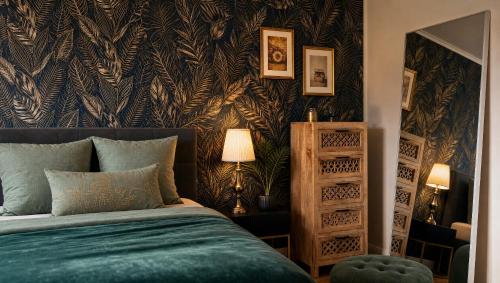 a bedroom with a bed and a patterned wall at Dreiländer Blick Apartment Premium in Lörrach