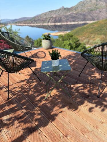 two chairs and a table on a deck with a view at Estrela do Gerês - Casa Fernandes in Outeiro