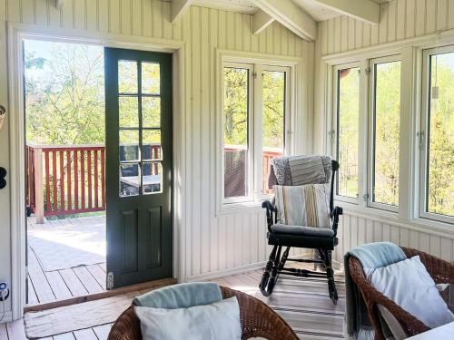 a porch with a rocking chair and a door at 5 person holiday home in Häradsbäck in Ryd