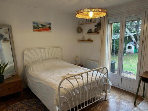 a bedroom with a white bed and a window at Maison familiale Tarnos, 4 chambres, jacuzzi in Tarnos