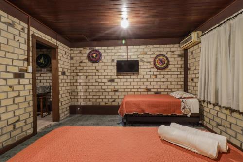 a bedroom with a bed and a tv in it at Pousada Zululand in Guarda do Embaú