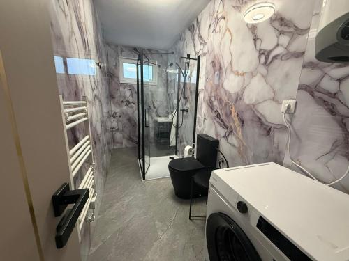 a bathroom with a shower and a washing machine at Self-Check- New Home in Levice