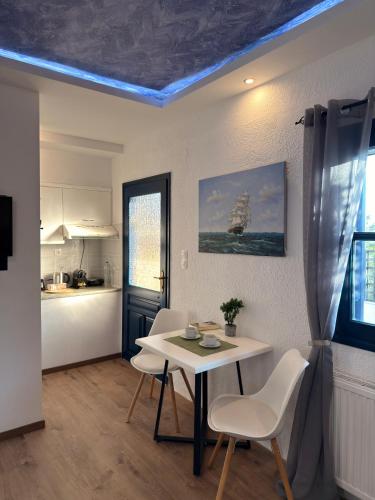 a kitchen with a table and chairs in a room at Archontarikia Luxury in Ouranoupoli